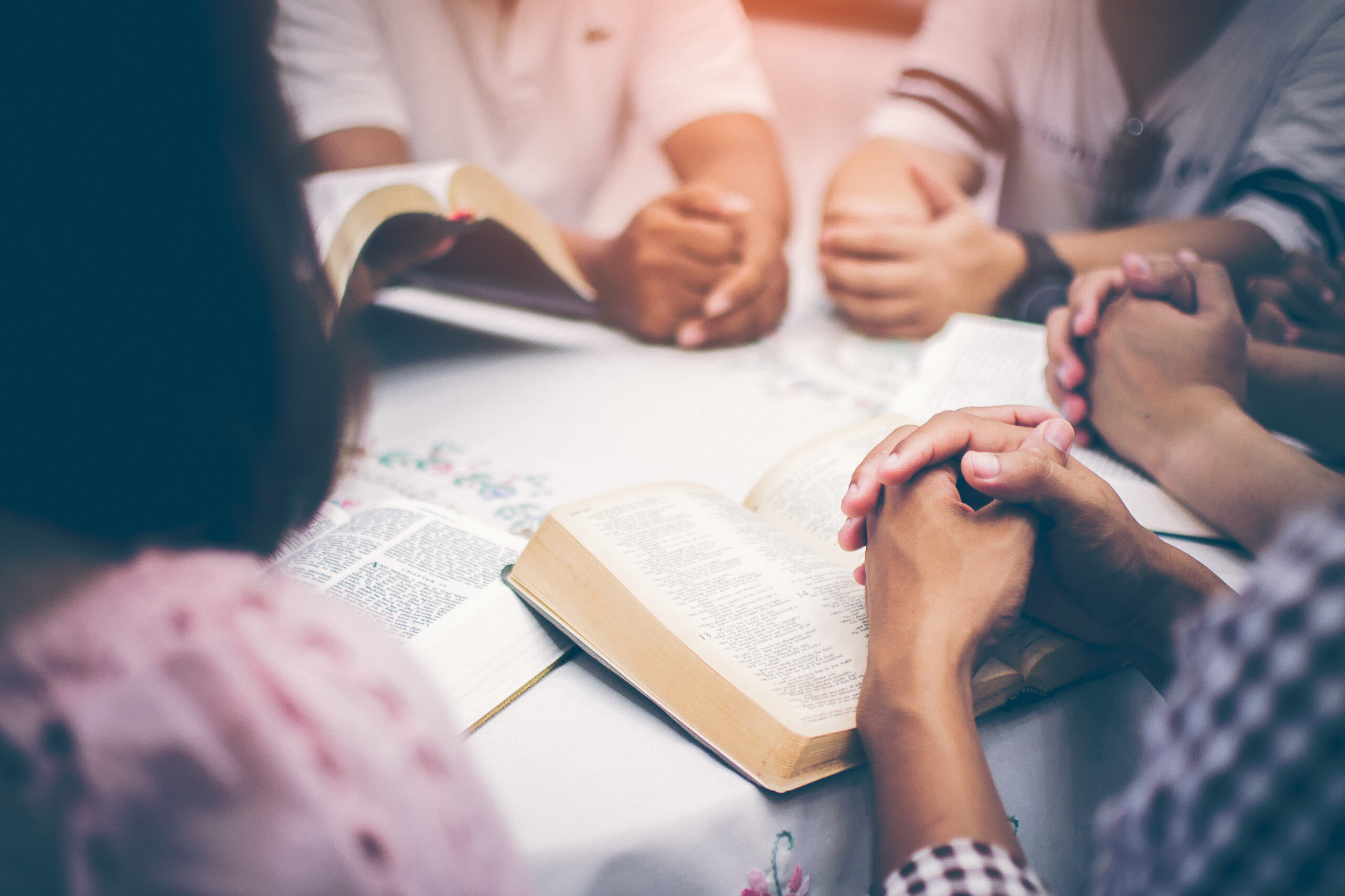 Christians are congregants join hands to pray and seek the blessings of God, the Holy Bible. They were reading the Bible and sharing the gospel with copy space.